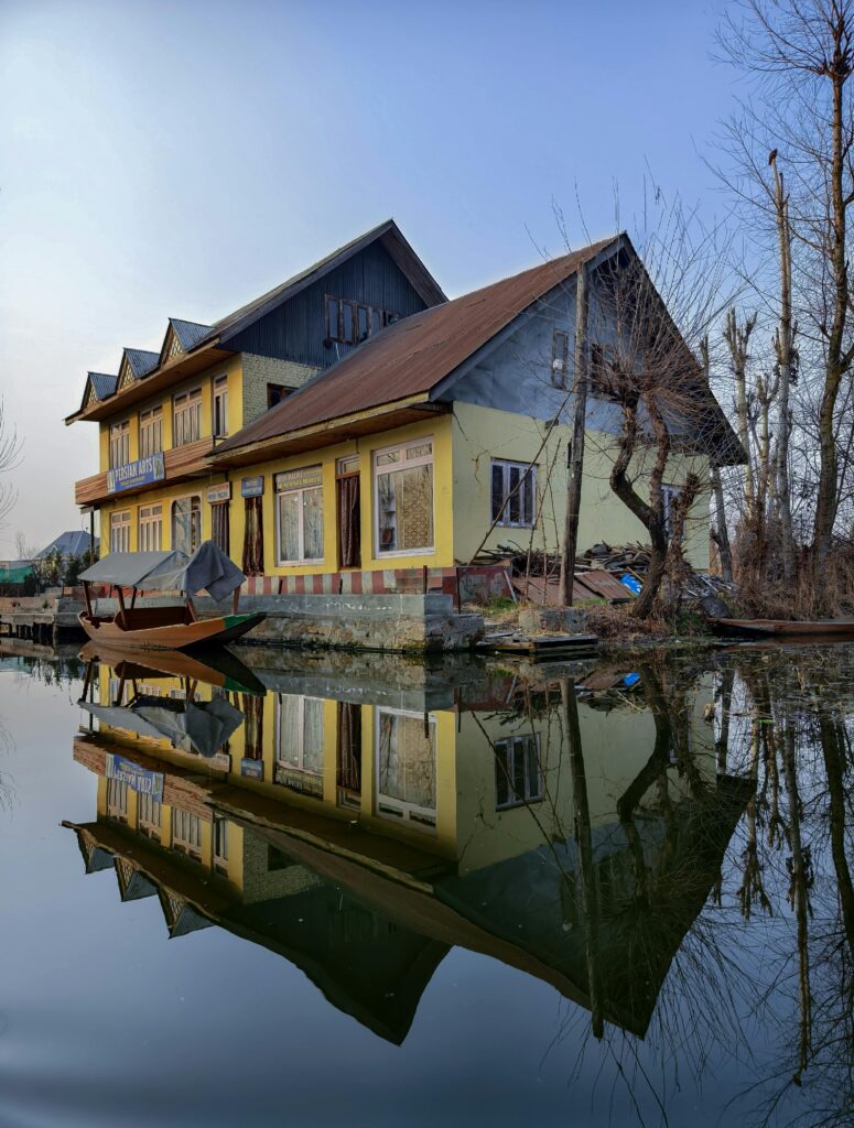 Charming reflection of a traditional house on Dal Lake, Srinagar. Serene and picturesque travel destination.